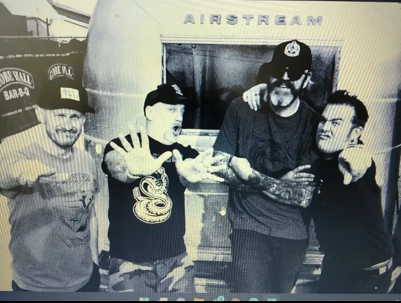 Image: punk band poses for photo in front of Airstream