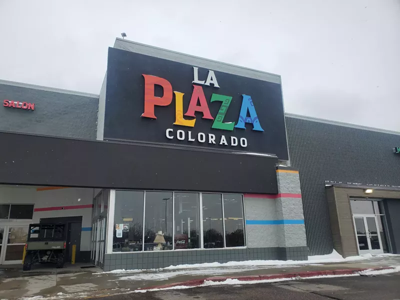 Image: front of a building with a colorful "la plaza" sign