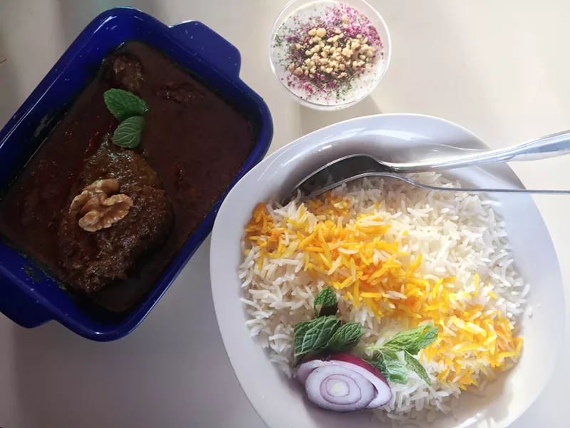 Image: Fesenjan, a walnut-pomegranate stew with braised chicken is served with fragrant rice and seasoned yogurt at Ladan's.