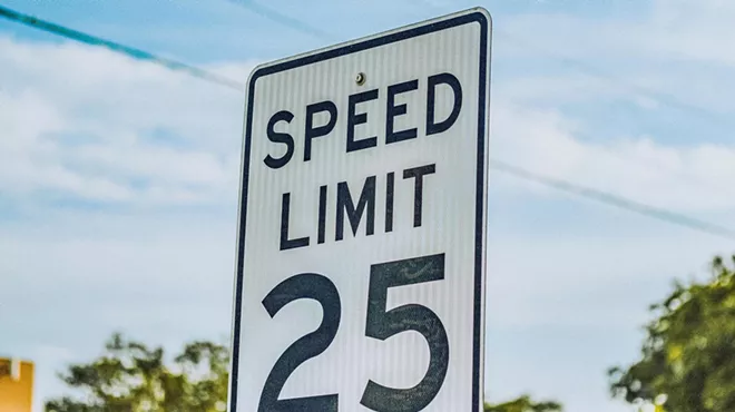 A 25 mph speed limit sign against a blue sky.