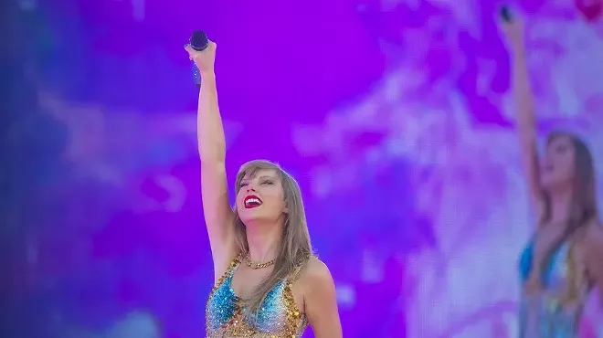 woman in a blue leotard holding a microphone