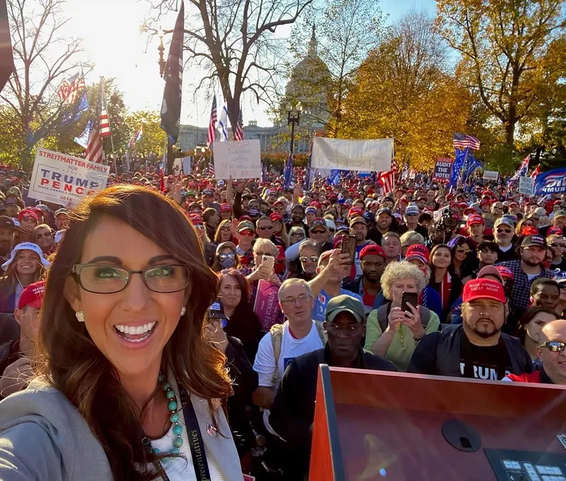 Image: The MillionMAGAMarch summed up in one tweeted photo: Lauren Boebert in front of a sole Black guy who looks like he's just realized where he's standing.