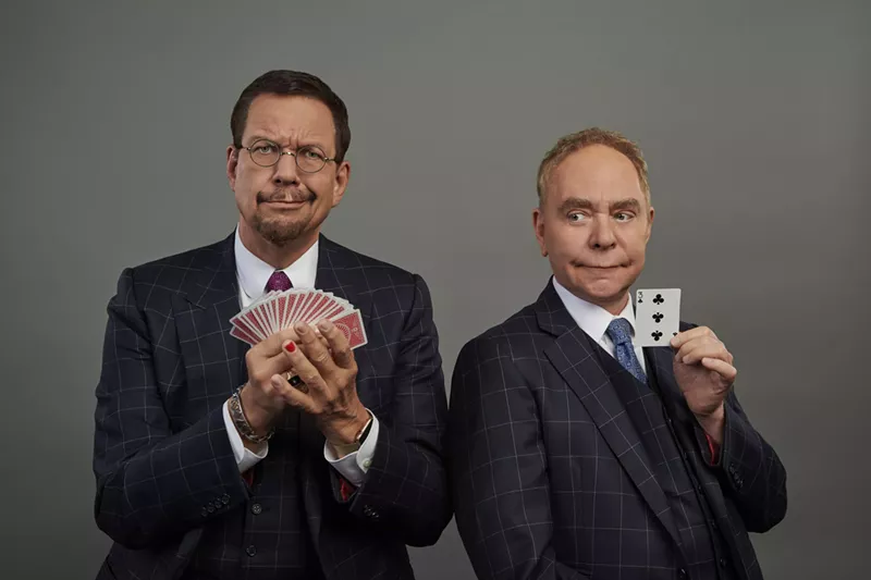 Image: two men in suits holding cards