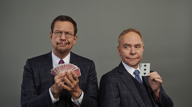 two men in suits holding cards
