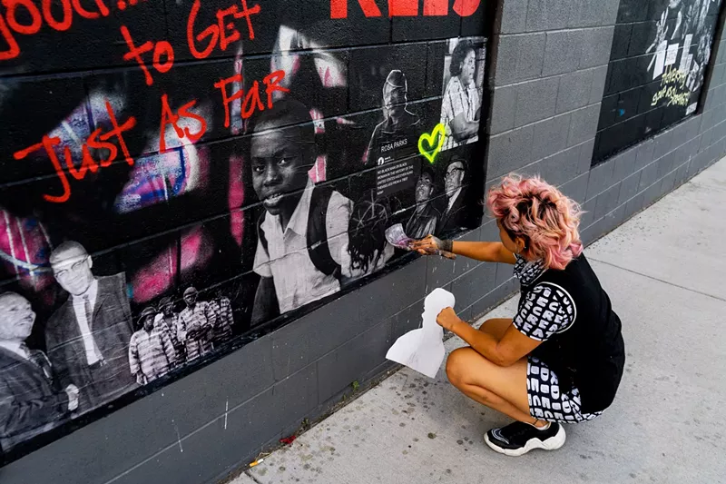 Image: Artist Samantha Aragon, aka Lil Fresh Sam, puts finishing touches on one of the panels in RiNo.