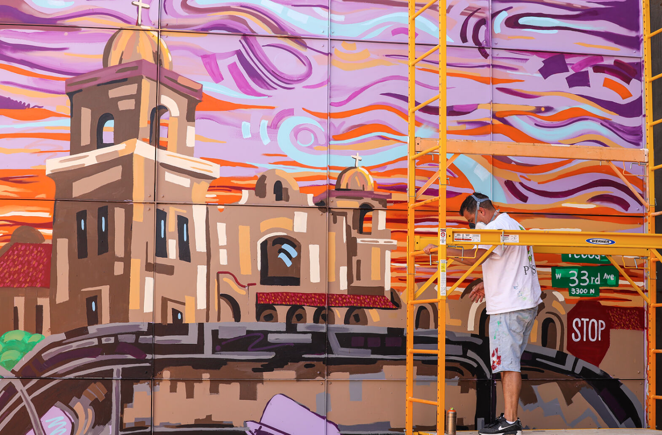 Ken Marley is pictured painting the Chicano Mural at Little Man Ice Cream.