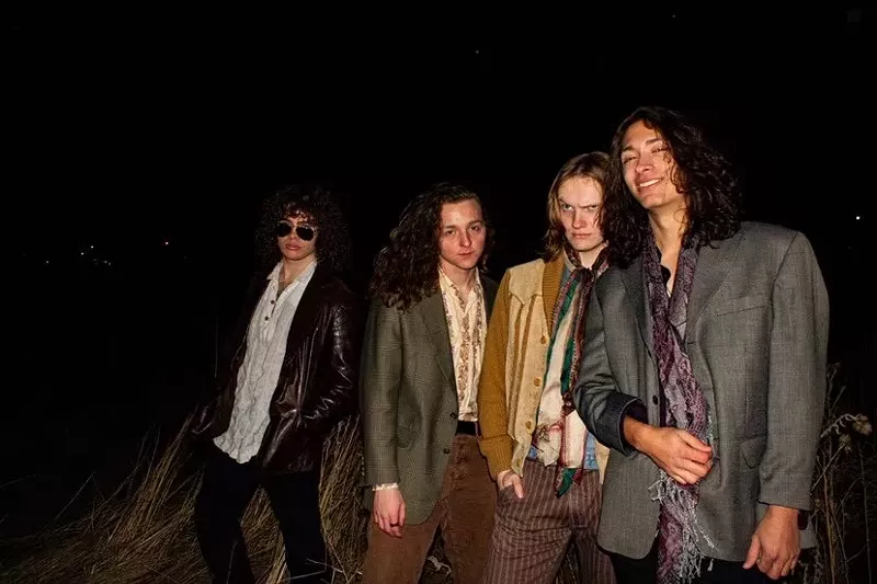 Image: four bandmates pose for a picture