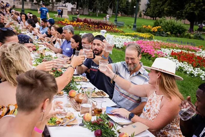 Image: People sharing a toast during a Longer Tables event in Civic Center Park