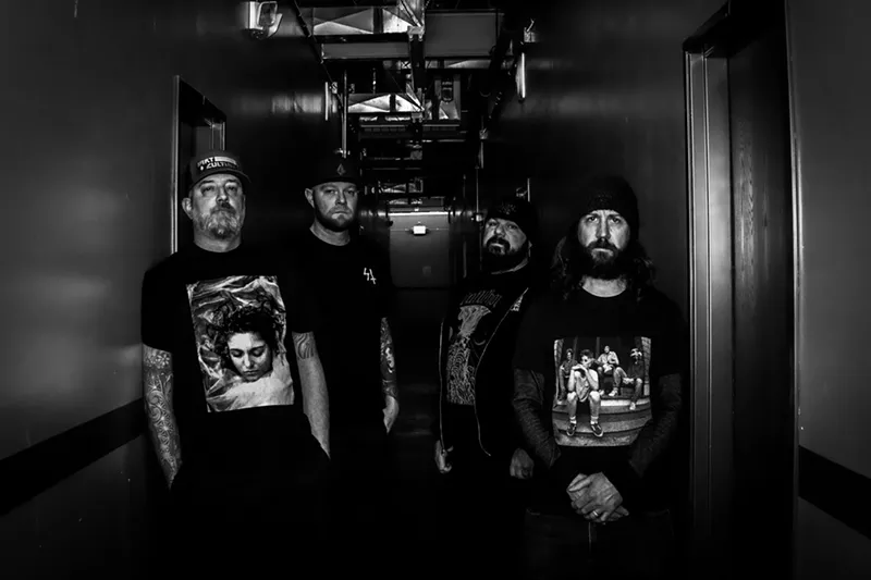 Image: metal bandmates stand next to each other in black-and-white photo