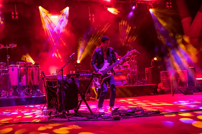 Image: band plays against red backdrop