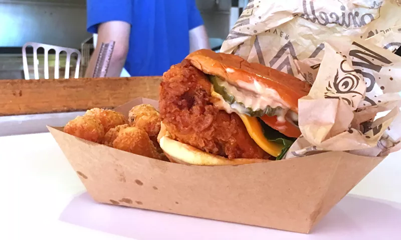 Image: The Lou's Plus hot chicken sandwich with tots.