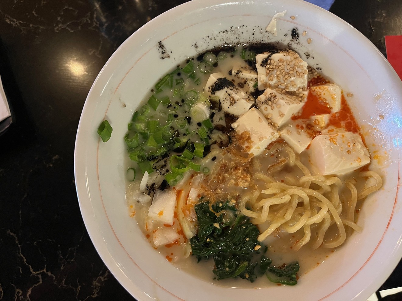 Jinya's spicy creamy vegan ramen includes tofu, spinach, crispy onion and garlic chips in vegetable broth.