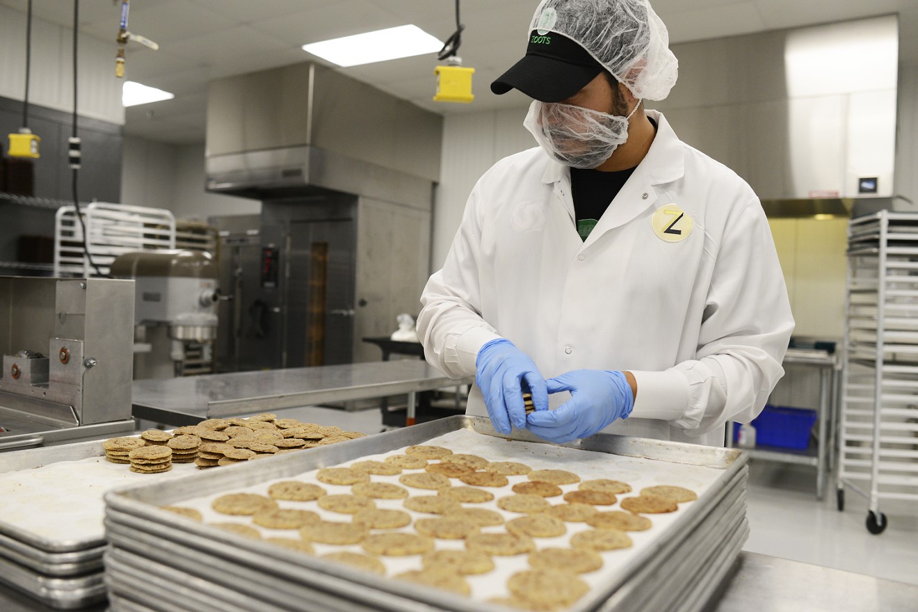 A Bronnor Corporation employee prepares Zoots infused snickerdoodles for packaging.
