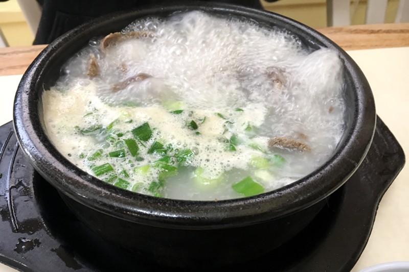 A bowl of beef soup called seolleongtang comes to the table at a rolling boil.