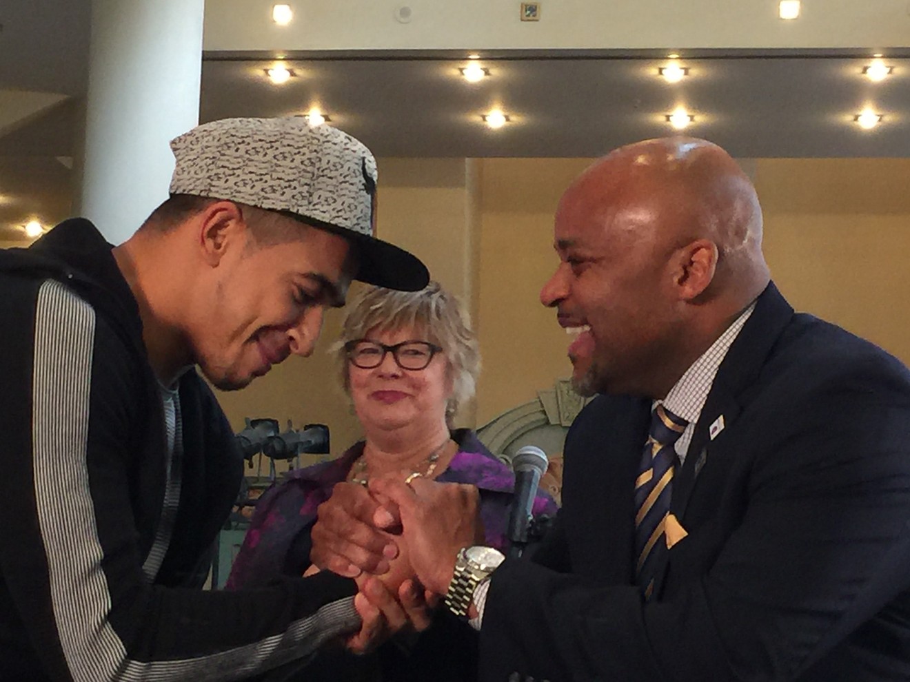 French dancer Salah and Mayor Michael Hancock share a moment of joy after a brief hip-hop dance lesson in front of the press. Jayne Buck of Visit Denver looks on.