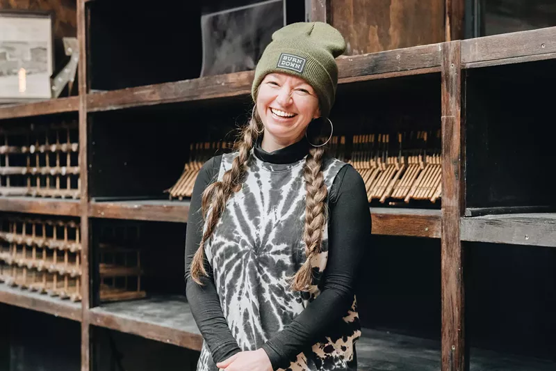 Image: woman smiling in black tie dye and green beanie