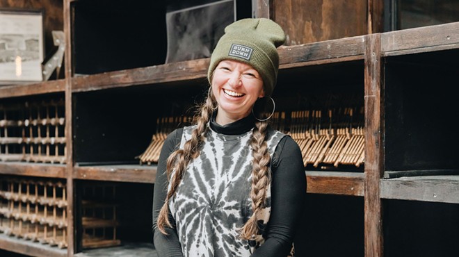 woman smiling in black tie dye and green beanie