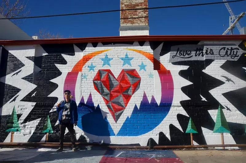 Image: Pat Milbery in front of one of three "Love This City" murals he painted for Visit Denver.