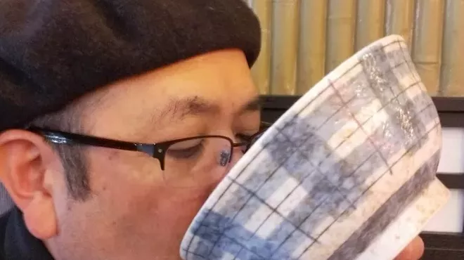 man in beret slurping ramen
