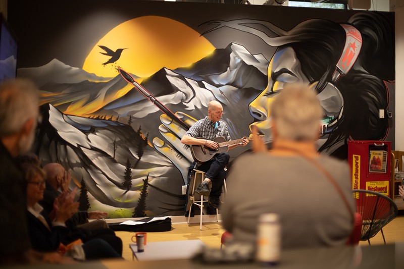 Marty Jones entertains the crowd in front of a mural by Chad Bolsinger in the Westword office.