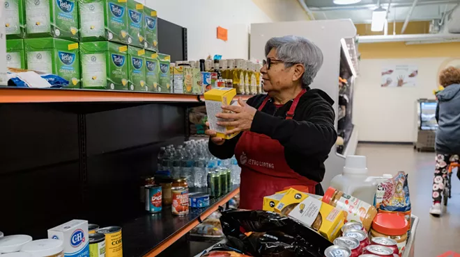 A Metro Caring volunteer stocking shelves at its charitable market