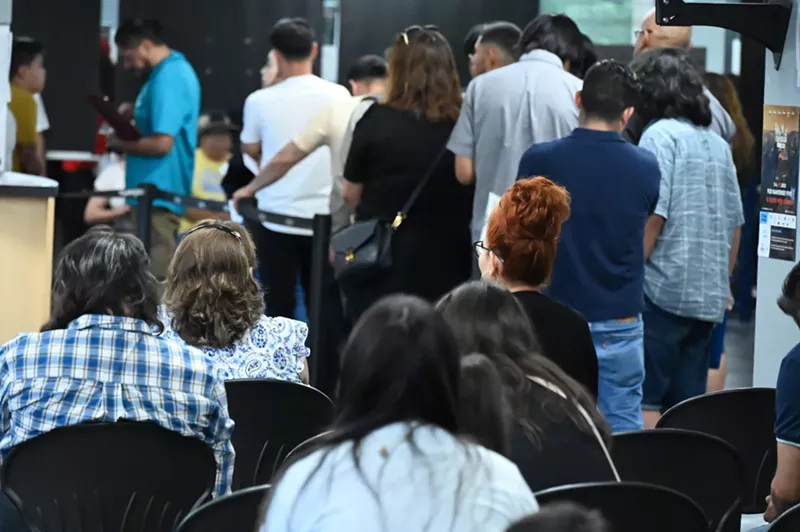 Image: People wait at a consulate.