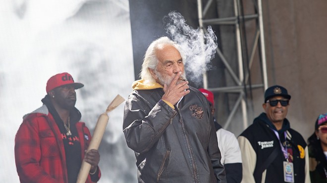 Tommy Chong smokes a joint on stage at the Denver 4/20 festival