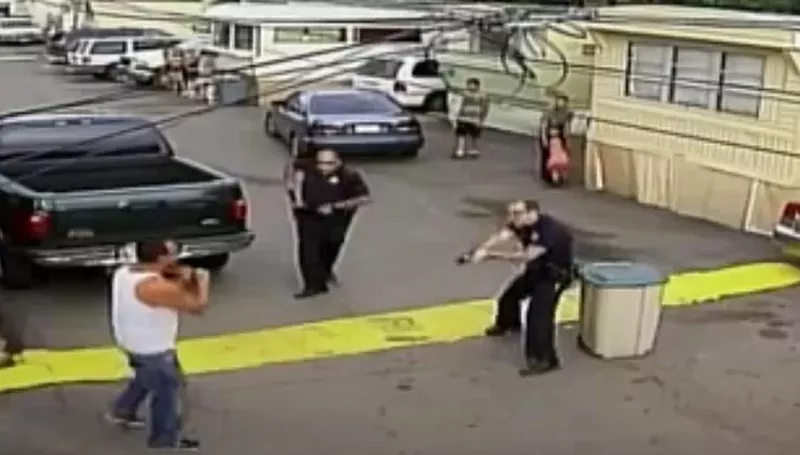 Image: Paul Castaway with a knife to his throat as he moves toward officers, as seen in surveillance footage.