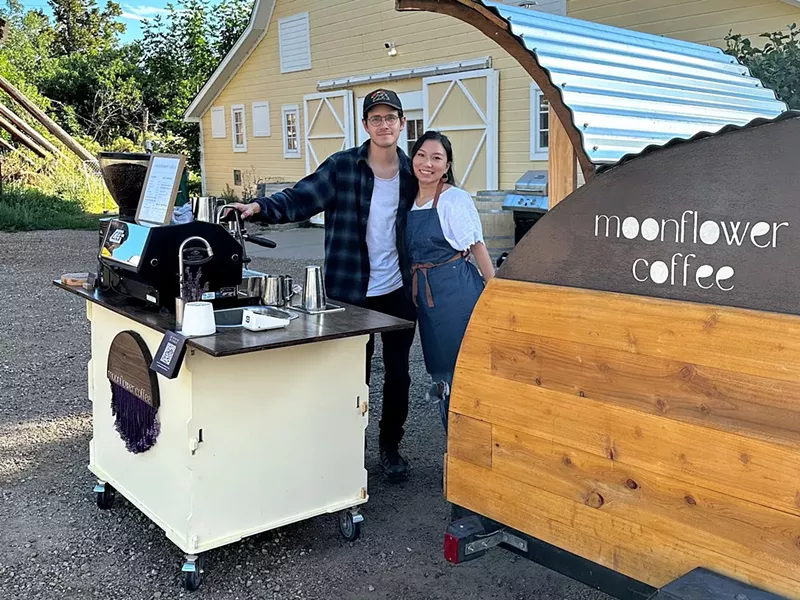 Image: two people standing next to a coffee cart