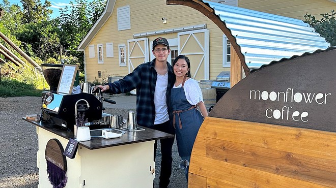 two people standing next to a coffee cart