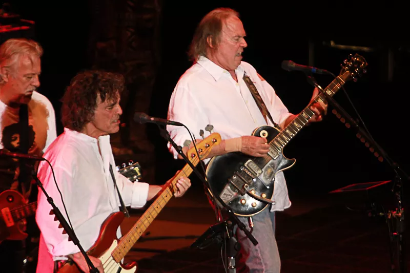Image: two men in white shirts playing guitar