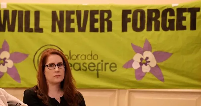 Image: woman by never forget banner