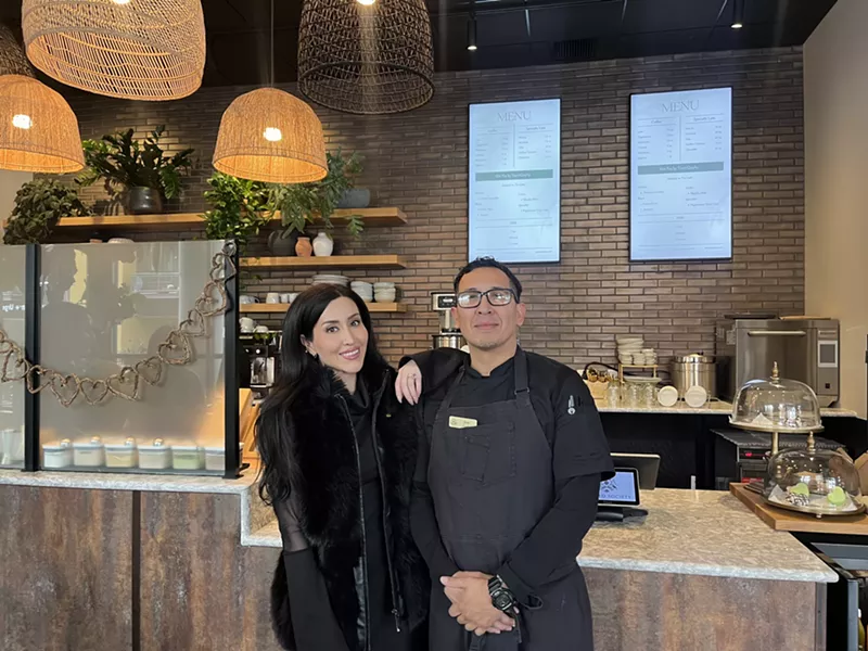Image: two people standing in a cafe