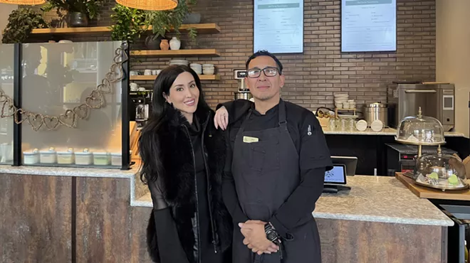 two people standing in a cafe