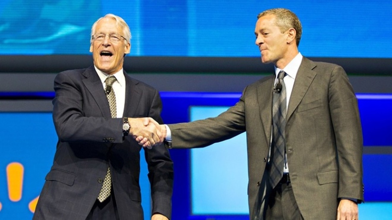 Rob Walton shaking hands with Greg Penner, Walmart chairman and his son-in-law.
