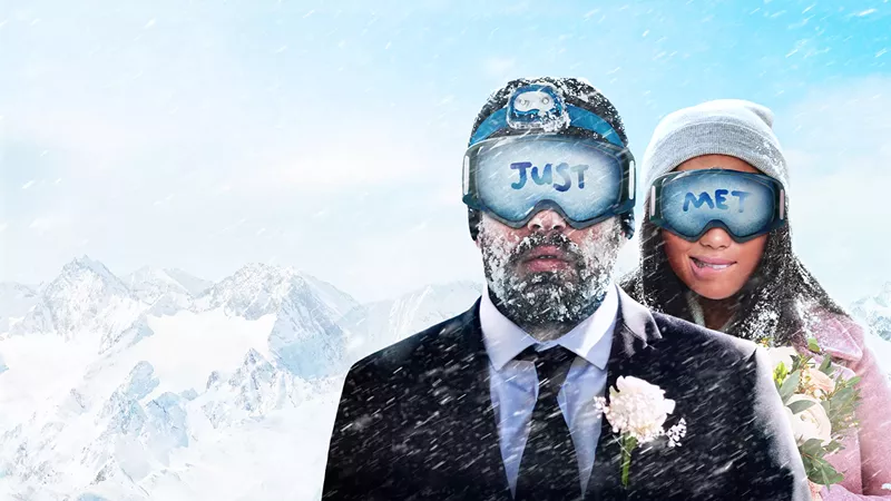 Image: bride and groom in snow and goggles.