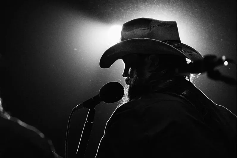 Image: man in a cowboy hat at amicrophone