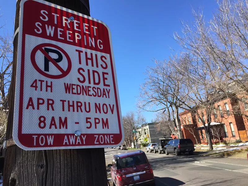 Image: A street sweeping sign bolted to a telephone pole on a Denver street.