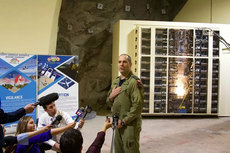 Image: Royal Canadian Air Force Colonel Travis Morehen in front of one of NORAD's blast doors.