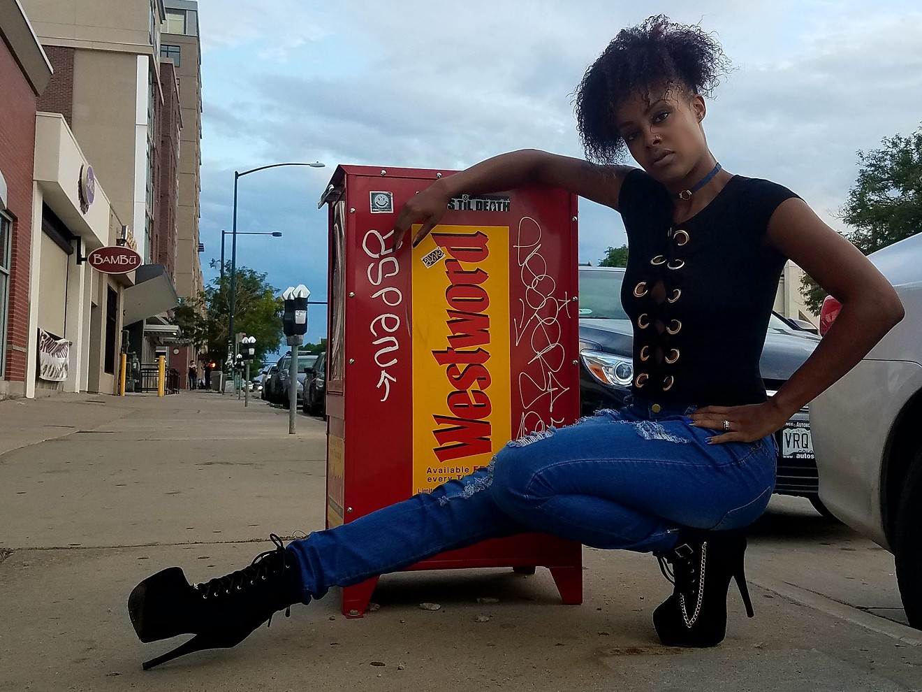 Part-time model Alicia Myers strikes a pose in front of a Westword box.