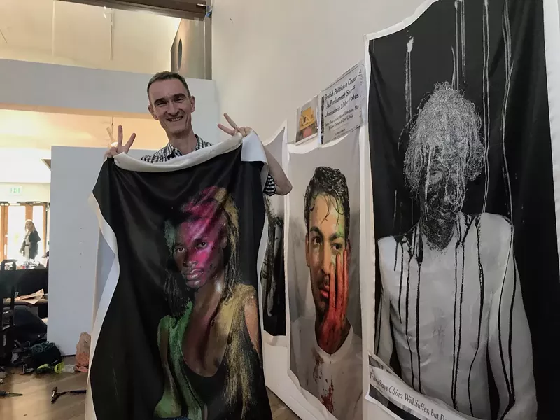 Image: Oliver Herring poses with photographic quilt blocks created for 31 Days.