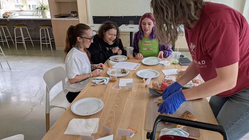 Image: youth at table picking pastries