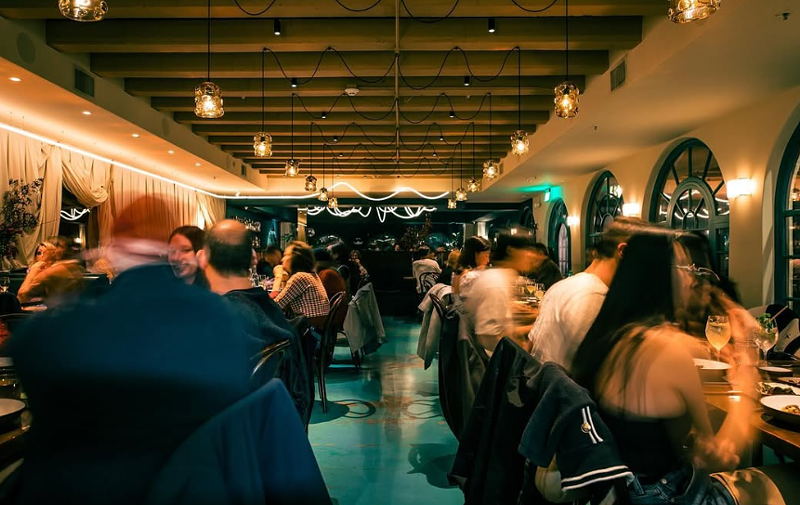 Image: people sitting at tables inside a restaurant