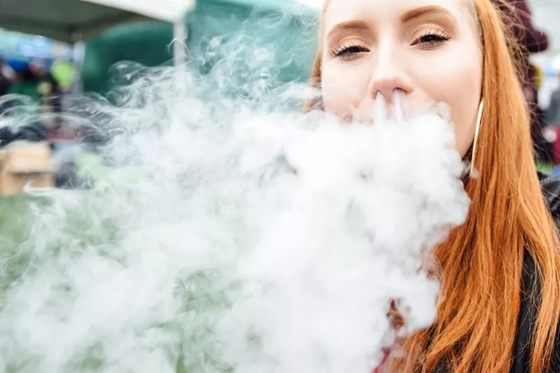 Image: redheaded girl vaping