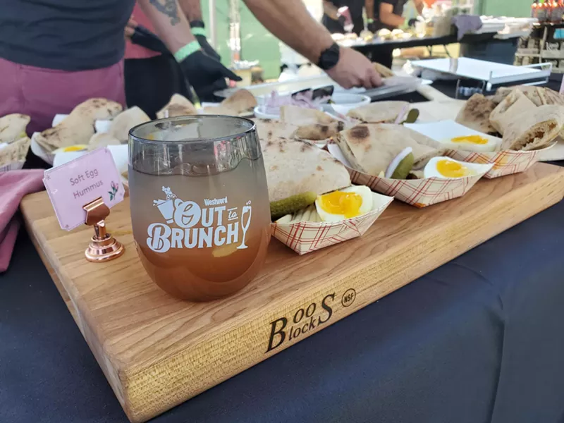 Image: a cup on a cutting board next to samples of hummus