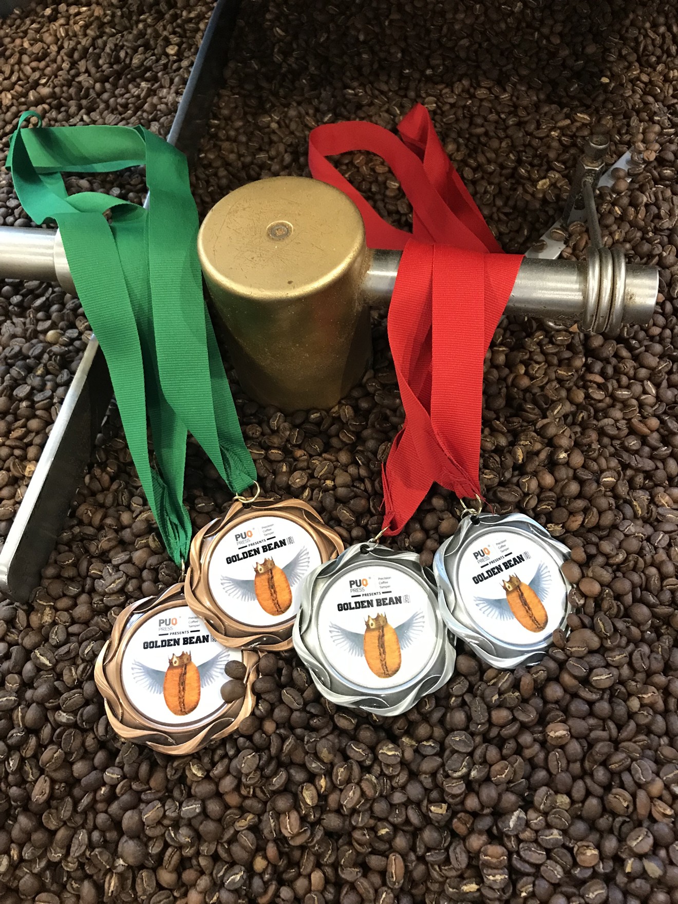 Medals and the coffee that won Pablo's recognition at the Golden Bean coffee competition.