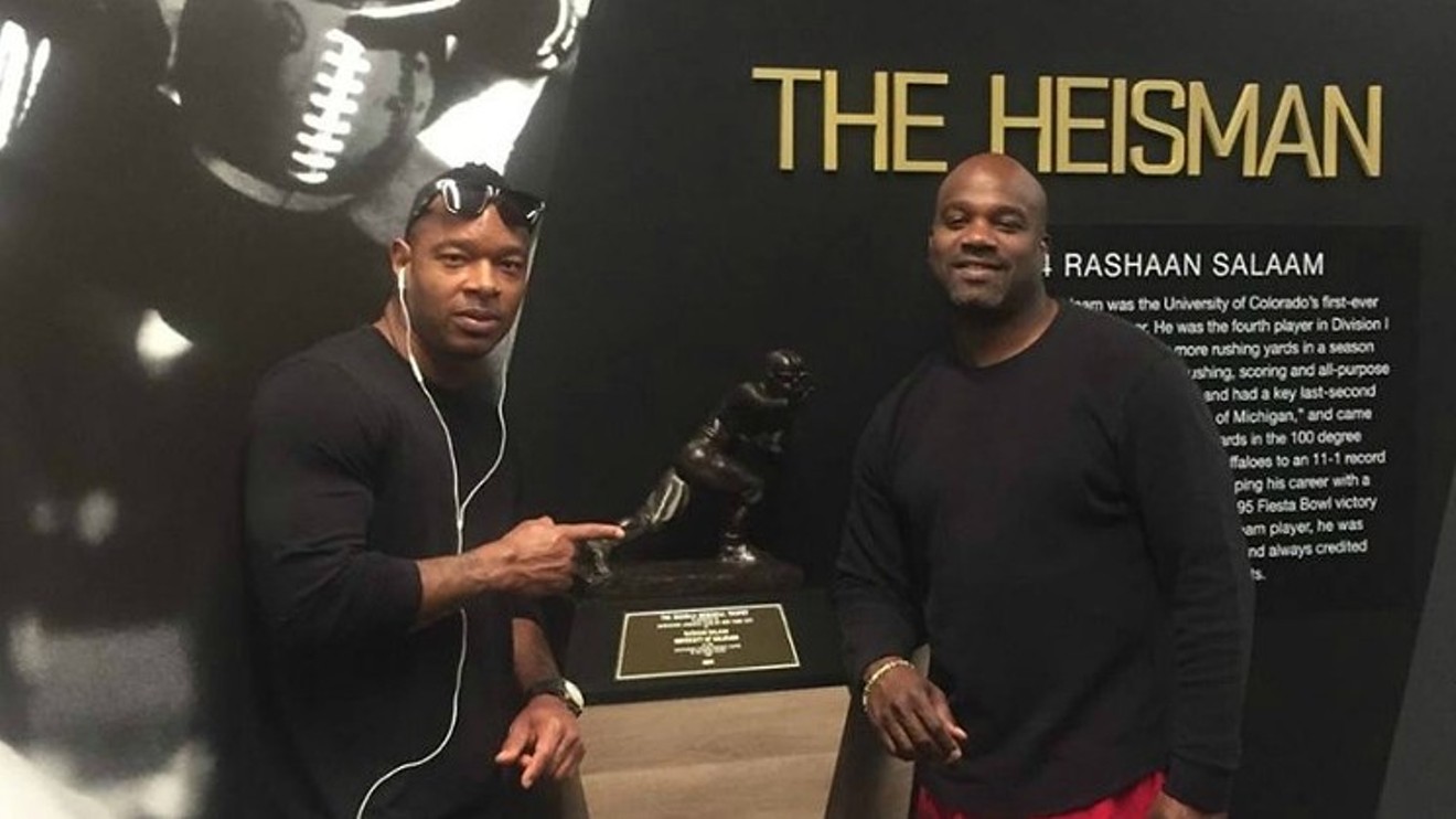 Rashaan Salaam, right, posing with his Heisman Trophy in a photo he shared on his Facebook page in April 2016, several months before he took his own life.