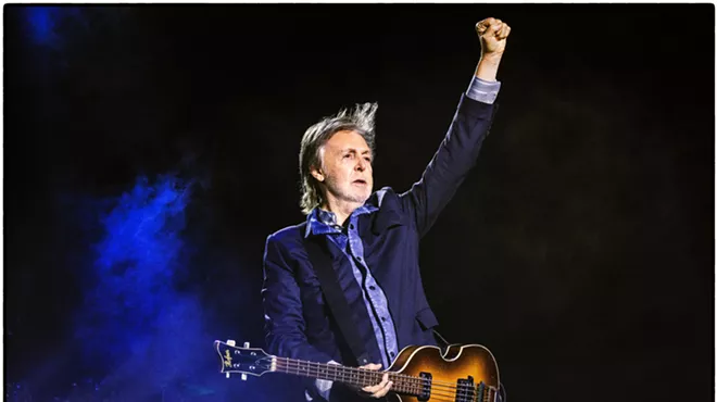 Paul McCartney with a guitar on stage