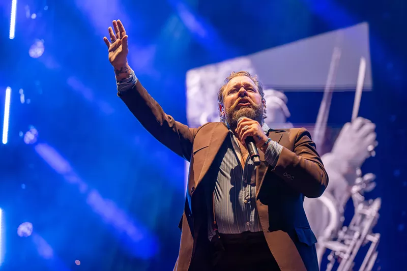 Image: Man in brown jacket singing