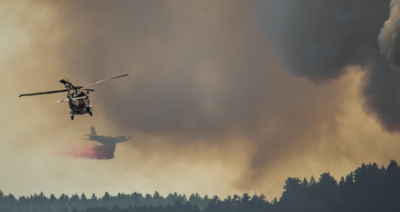 A slurry air tanker was quickly chased by a helicopter with water to hit hot spots in Deer Creek Canyon on July 30.